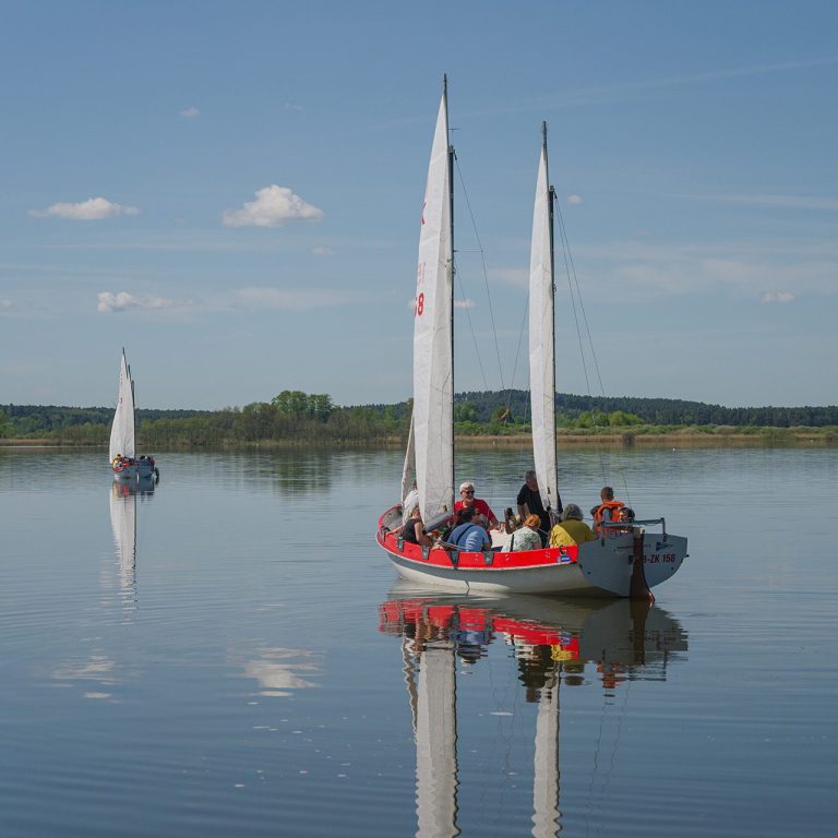 Zwei Segelboote auf dem Rabgsdorfer See mit blauem Himmel und Spiegelung.
